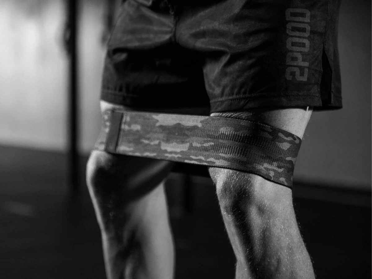 Athlete performing hip circle band warm-up in quarter squat stance at Bax Performance and Rehab in Pleasanton, CA to improve hip activation and squat mechanics.